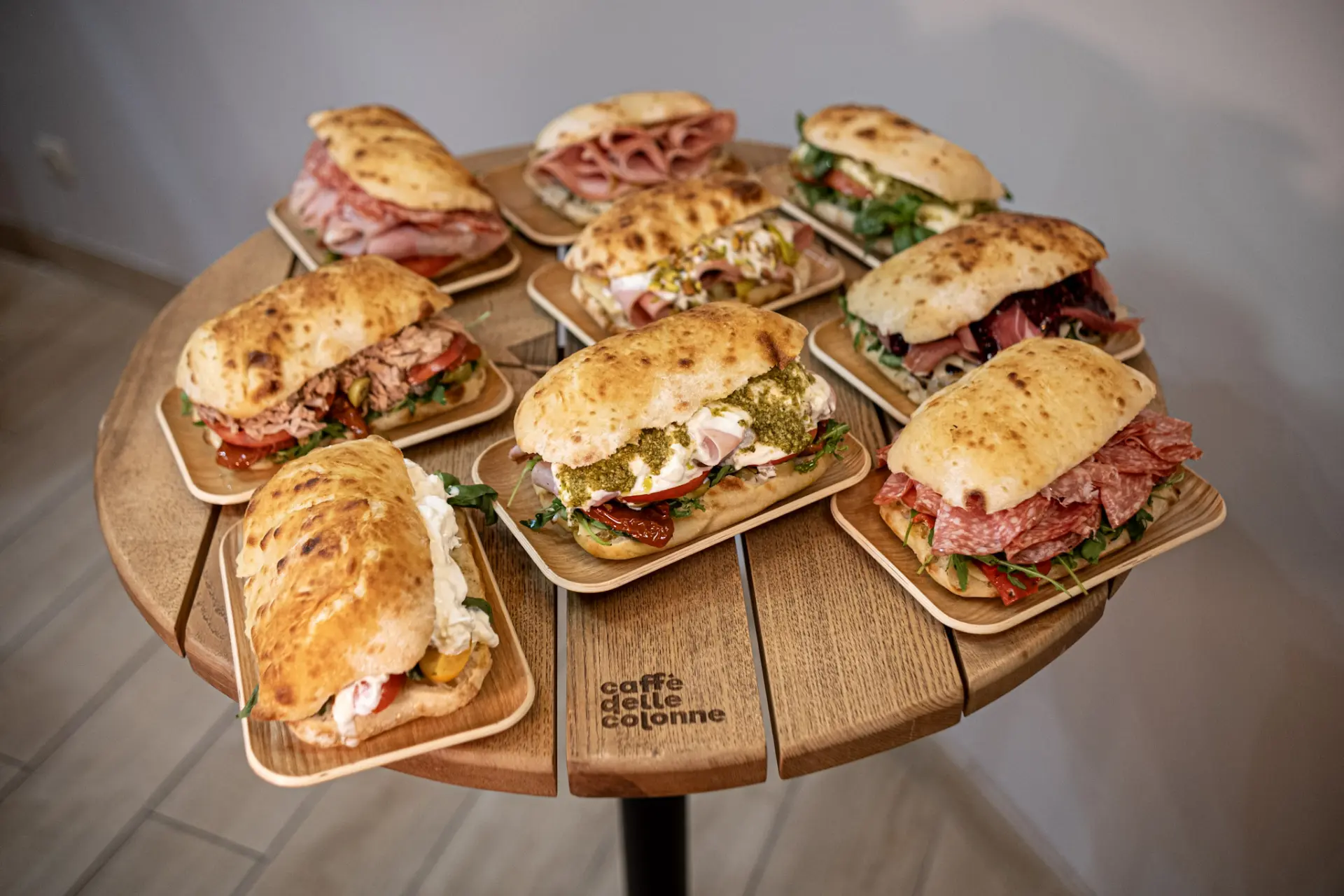 Nine Caffè delle Colonne panini on a round wooden table